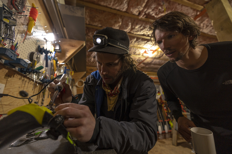 ralphie_I1A0336-3(1).jpg :: Markus Eder looks on as Eric Hjorleifson works on his ski boots at Sentry Lodge, BC  Photo: Bryan Ralph
