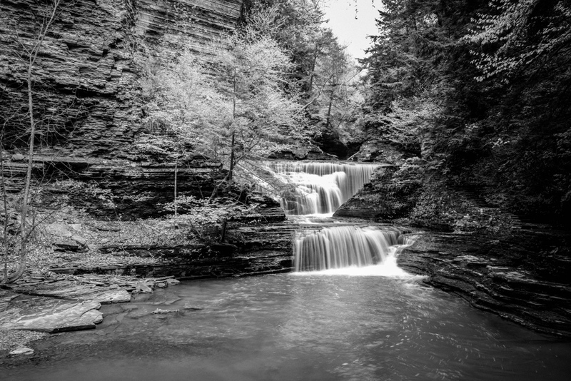 Bushkill Falls - lower pool.jpg :: Water falls into a shallow pool with rock formations and trees.
