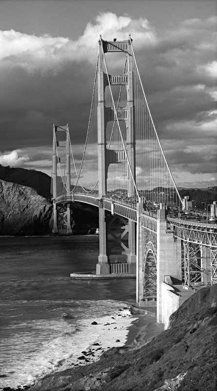 San Francisco--Golden Gate and Cloud Shadows -- Vertical Panorama.jpg :: Golden Gate Bridge from San Francisco side looking north across Marin Headlands into Marin County.  Exposed 4:00 PM on March 30, 2010 though 250 mm lens behind deep red filter on Hasselblad 500 CM with aperture at f/16 and exposure at one quarter second using TMax 100 film. The image was made by exposing one frame capturing the bottom half of the image and then rotating the camera upward while keeping the lens azimuth unchanged and exposing a second frame capturing the top half of the image. Once developed, the two negatives were scanned and merged digitally to create the \
