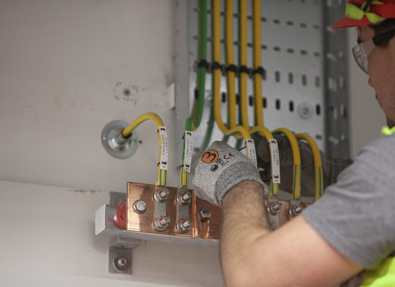 Technical Installation  Precision Electrical Grounding.jpg :: A detailed study of copper grounding busbar installation. Documenting the precision and focus required for electrical infrastructure in specialized industrial environments.