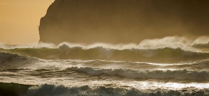 CAPE KIWANDA_-.jpg :: THREE CAPES SCENIC ROUTE - OREGON COAST.    
The setting sun backlights the windswept waves rolling in from the open Pacific Ocean.