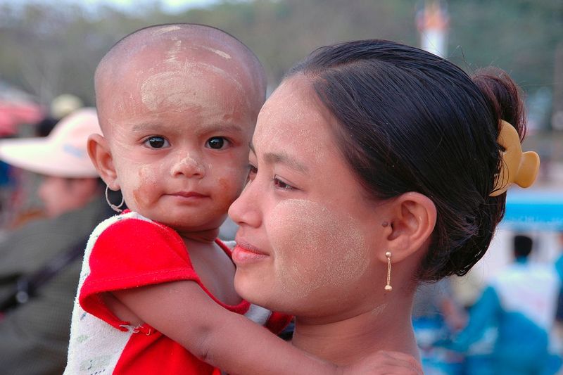 HOPE FOR MYANMAR.jpg :: MAE SOT PROVINCE, THAILAND.   A Burmese woman and her child pause a moment amongst the hectic day market scene at the border of Thailand and Burma