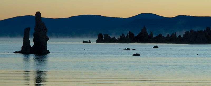 MONO MIST.jpg :: SOUTH TUFA - MONO LAKE, CALIFORNIA.    
A deep mist springs from the cool lake water surface as sunrise approaches. 
The magical tufa formations of Mono Lake are ancient underwater alkali springs which were exposed after many years of dewatering by thirsty suburban Southern California. 
These formations will slowly disappear back into the lake depths thanks to many years of legal battles and recent court decisions to restore lake levels. 

