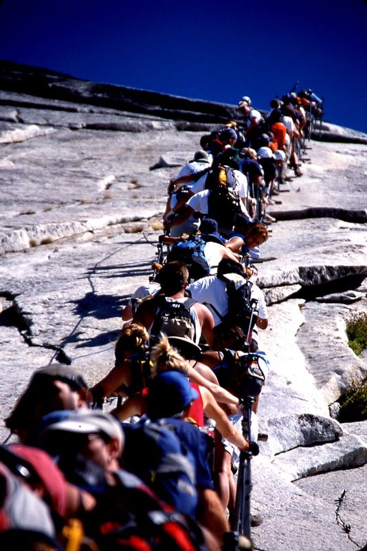 RUSH HOUR.jpg :: HALF DOME - YOSEMITE NATIONAL PARK, CALIFORNIA.   
Each afternoon during the summer season, many hikers attempt the long and arduous hike to the top of half dome.  The final ascent culminates at a series of cables that allow a very steep ascent and decent.  Unfortunately, most arrive at the same time creating legendary backups.