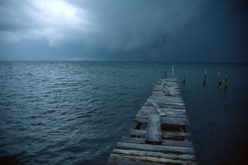 STORM APPROACHING.jpg :: BLUE GROUND CAYE, BELIZE.    
A dilapidated pier silently awaits as a dark foreboding storm approaches 



