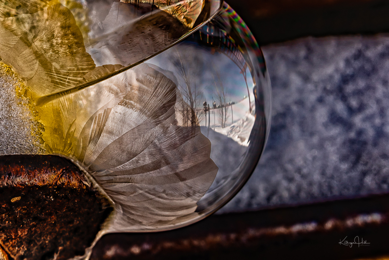 Amber Bubble.jpg :: Frozen fingers of ice and sugar crystals form on a soap bubble on an old piece of patinated farm equipment - deep winter in Colorado, USA.