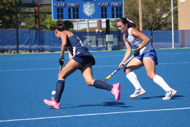 Saint Louis University (SLU) Field Hockey vs UC Davis 2025 LIV.jpg :: SLU Field Hockey vs University of California Davis at the SLU Field Hockey Complex - Women's Field Hockey - The standard field size for field hockey is 300 feet (100 meters) long and 167 feet wide. A field hockey field's boundaries are marked with the end lines going across the width and sidelines going across the length. - The field is divided into quarters by four lines. The 25-yard line are 25 yards from each end line, and the center line runs through the middle of the field. The goalposts are 12 feet wide, 7 feet tall, and 4 feet deep. Each goal post is situated in the center of each end line. - The Striking Circle is a Semi-Circle with a radius of around 48 feet surrounding each goal. - There are always 22 players on the field, 11 from each team. Each team has a goalkeeper and 10 fielders.