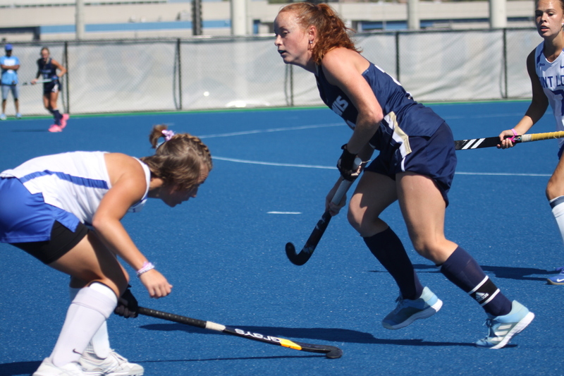 Saint Louis University (SLU) Field Hockey vs UC Davis 2025 LVI.jpg :: SLU Field Hockey vs University of California Davis at the SLU Field Hockey Complex - Women's Field Hockey - The standard field size for field hockey is 300 feet (100 meters) long and 167 feet wide. A field hockey field's boundaries are marked with the end lines going across the width and sidelines going across the length. - The field is divided into quarters by four lines. The 25-yard line are 25 yards from each end line, and the center line runs through the middle of the field. The goalposts are 12 feet wide, 7 feet tall, and 4 feet deep. Each goal post is situated in the center of each end line. - The Striking Circle is a Semi-Circle with a radius of around 48 feet surrounding each goal. - There are always 22 players on the field, 11 from each team. Each team has a goalkeeper and 10 fielders.