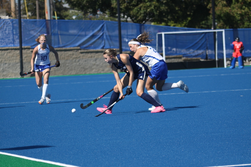 Saint Louis University (SLU) Field Hockey vs UC Davis 2025 XXIII.jpg :: SLU Field Hockey vs University of California Davis at the SLU Field Hockey Complex - Women's Field Hockey - The standard field size for field hockey is 300 feet (100 meters) long and 167 feet wide. A field hockey field's boundaries are marked with the end lines going across the width and sidelines going across the length. - The field is divided into quarters by four lines. The 25-yard line are 25 yards from each end line, and the center line runs through the middle of the field. The goalposts are 12 feet wide, 7 feet tall, and 4 feet deep. Each goal post is situated in the center of each end line. - The Striking Circle is a Semi-Circle with a radius of around 48 feet surrounding each goal. - There are always 22 players on the field, 11 from each team. Each team has a goalkeeper and 10 fielders.