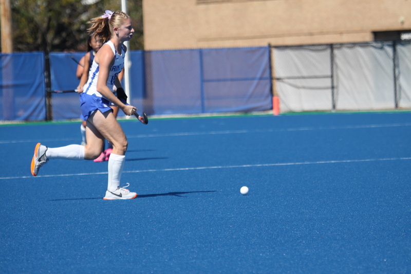 Saint Louis University (SLU) Field Hockey vs UC Davis 2025 XXIX.jpg :: SLU Field Hockey vs University of California Davis at the SLU Field Hockey Complex - Women's Field Hockey - The standard field size for field hockey is 300 feet (100 meters) long and 167 feet wide. A field hockey field's boundaries are marked with the end lines going across the width and sidelines going across the length. - The field is divided into quarters by four lines. The 25-yard line are 25 yards from each end line, and the center line runs through the middle of the field. The goalposts are 12 feet wide, 7 feet tall, and 4 feet deep. Each goal post is situated in the center of each end line. - The Striking Circle is a Semi-Circle with a radius of around 48 feet surrounding each goal. - There are always 22 players on the field, 11 from each team. Each team has a goalkeeper and 10 fielders.