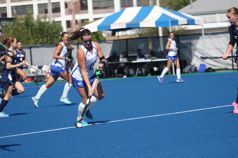 Saint Louis University (SLU) Field Hockey vs UC Davis 2025 XXV.jpg :: SLU Field Hockey vs University of California Davis at the SLU Field Hockey Complex - Women's Field Hockey - The standard field size for field hockey is 300 feet (100 meters) long and 167 feet wide. A field hockey field's boundaries are marked with the end lines going across the width and sidelines going across the length. - The field is divided into quarters by four lines. The 25-yard line are 25 yards from each end line, and the center line runs through the middle of the field. The goalposts are 12 feet wide, 7 feet tall, and 4 feet deep. Each goal post is situated in the center of each end line. - The Striking Circle is a Semi-Circle with a radius of around 48 feet surrounding each goal. - There are always 22 players on the field, 11 from each team. Each team has a goalkeeper and 10 fielders.