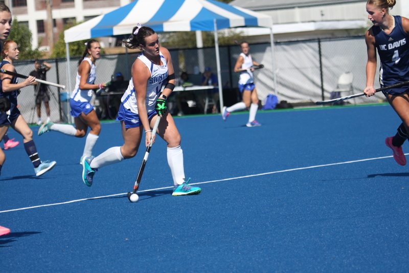 Saint Louis University (SLU) Field Hockey vs UC Davis 2025 XXVI.jpg :: SLU Field Hockey vs University of California Davis at the SLU Field Hockey Complex - Women's Field Hockey - The standard field size for field hockey is 300 feet (100 meters) long and 167 feet wide. A field hockey field's boundaries are marked with the end lines going across the width and sidelines going across the length. - The field is divided into quarters by four lines. The 25-yard line are 25 yards from each end line, and the center line runs through the middle of the field. The goalposts are 12 feet wide, 7 feet tall, and 4 feet deep. Each goal post is situated in the center of each end line. - The Striking Circle is a Semi-Circle with a radius of around 48 feet surrounding each goal. - There are always 22 players on the field, 11 from each team. Each team has a goalkeeper and 10 fielders.