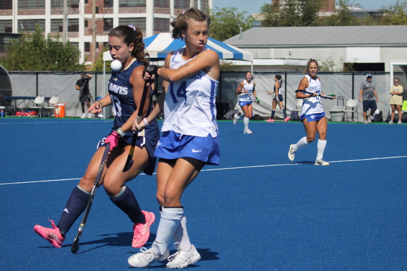 Saint Louis University (SLU) Field Hockey vs UC Davis 2025 XXVII.jpg :: SLU Field Hockey vs University of California Davis at the SLU Field Hockey Complex - Women's Field Hockey - The standard field size for field hockey is 300 feet (100 meters) long and 167 feet wide. A field hockey field's boundaries are marked with the end lines going across the width and sidelines going across the length. - The field is divided into quarters by four lines. The 25-yard line are 25 yards from each end line, and the center line runs through the middle of the field. The goalposts are 12 feet wide, 7 feet tall, and 4 feet deep. Each goal post is situated in the center of each end line. - The Striking Circle is a Semi-Circle with a radius of around 48 feet surrounding each goal. - There are always 22 players on the field, 11 from each team. Each team has a goalkeeper and 10 fielders.