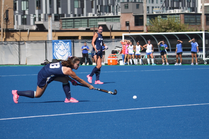 Saint Louis University (SLU) Field Hockey vs UC Davis 2025 XXVIII.jpg :: SLU Field Hockey vs University of California Davis at the SLU Field Hockey Complex - Women's Field Hockey - The standard field size for field hockey is 300 feet (100 meters) long and 167 feet wide. A field hockey field's boundaries are marked with the end lines going across the width and sidelines going across the length. - The field is divided into quarters by four lines. The 25-yard line are 25 yards from each end line, and the center line runs through the middle of the field. The goalposts are 12 feet wide, 7 feet tall, and 4 feet deep. Each goal post is situated in the center of each end line. - The Striking Circle is a Semi-Circle with a radius of around 48 feet surrounding each goal. - There are always 22 players on the field, 11 from each team. Each team has a goalkeeper and 10 fielders.
