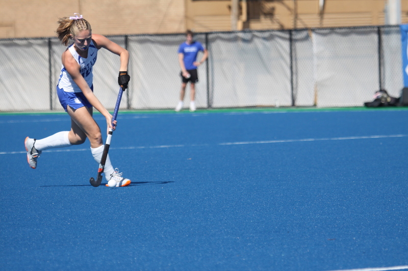 Saint Louis University (SLU) Field Hockey vs UC Davis 2025 XXXI.jpg :: SLU Field Hockey vs University of California Davis at the SLU Field Hockey Complex - Women's Field Hockey - The standard field size for field hockey is 300 feet (100 meters) long and 167 feet wide. A field hockey field's boundaries are marked with the end lines going across the width and sidelines going across the length. - The field is divided into quarters by four lines. The 25-yard line are 25 yards from each end line, and the center line runs through the middle of the field. The goalposts are 12 feet wide, 7 feet tall, and 4 feet deep. Each goal post is situated in the center of each end line. - The Striking Circle is a Semi-Circle with a radius of around 48 feet surrounding each goal. - There are always 22 players on the field, 11 from each team. Each team has a goalkeeper and 10 fielders.