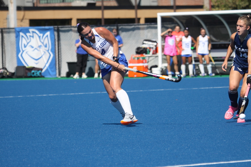 Saint Louis University (SLU) Field Hockey vs UC Davis 2025 XXXIV.jpg :: SLU Field Hockey vs University of California Davis at the SLU Field Hockey Complex - Women's Field Hockey - The standard field size for field hockey is 300 feet (100 meters) long and 167 feet wide. A field hockey field's boundaries are marked with the end lines going across the width and sidelines going across the length. - The field is divided into quarters by four lines. The 25-yard line are 25 yards from each end line, and the center line runs through the middle of the field. The goalposts are 12 feet wide, 7 feet tall, and 4 feet deep. Each goal post is situated in the center of each end line. - The Striking Circle is a Semi-Circle with a radius of around 48 feet surrounding each goal. - There are always 22 players on the field, 11 from each team. Each team has a goalkeeper and 10 fielders.