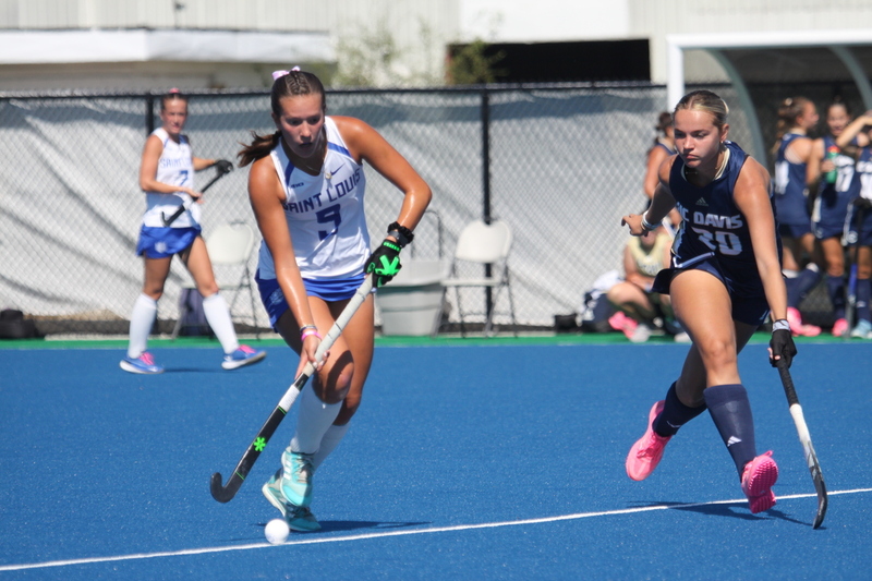 Saint Louis University (SLU) Field Hockey vs UC Davis 2025 XXXXV.jpg :: SLU Field Hockey vs University of California Davis at the SLU Field Hockey Complex - Women's Field Hockey - The standard field size for field hockey is 300 feet (100 meters) long and 167 feet wide. A field hockey field's boundaries are marked with the end lines going across the width and sidelines going across the length. - The field is divided into quarters by four lines. The 25-yard line are 25 yards from each end line, and the center line runs through the middle of the field. The goalposts are 12 feet wide, 7 feet tall, and 4 feet deep. Each goal post is situated in the center of each end line. - The Striking Circle is a Semi-Circle with a radius of around 48 feet surrounding each goal. - There are always 22 players on the field, 11 from each team. Each team has a goalkeeper and 10 fielders.