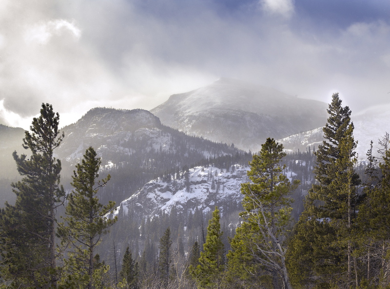 Under Storm Pass.jpg :: I was driving up a very steep and switchbacky road and saw this in the rear view mirror, and had to stop to at least try to get it.  I had gotten out my tripod and back pack with my large camera when a ranger came along and told me I could not stop there.  I packed up and moved on up the road, made a u-turn, stopped in the spot, jumped out and got the photograph... just not with my large film camera.