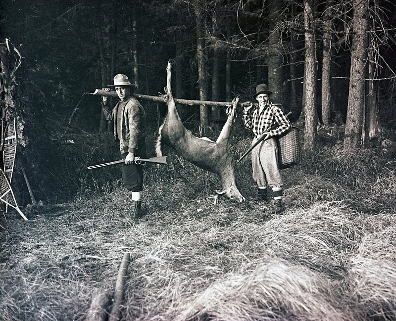 CCE 3-210 carrying deer in woods w friend c. 1926 ORIG. GLASS NEG.SCAN.jpg