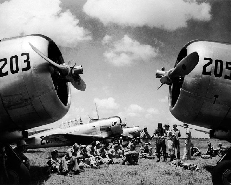 ON 1-83  pilots sitting on Florida airfield framed by nosecones of airplanes 19421.jpg