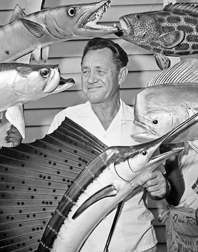 CELEBRITIES (2-251LR) Al Pfleuger taxidermist surrounded by his mounts in shop.jpg