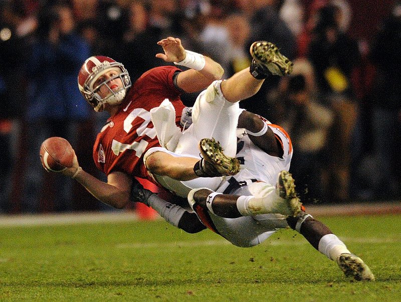111026   AUBURN ALABAMA_002.jpg :: Alabama quarterback Greg McElroy (12) is tackled by Auburn defensive back T'Sharvan Bell (22) in the fourth quarter in the Iron Bowl at Bryant-Denny Stadium November 26, 2010 in Tuscaloosa, Ala. Auburn wins 28-27. (The Birmingham News, Hal Yeager)