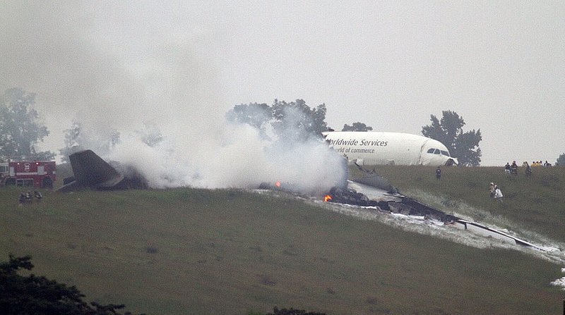 ALHY 104.jpg :: Parts of debris burns as an A300 cargo plane lies on a hill at Birmingham Shuttlesworth International Airport after crashing on approach this morning Wednesday August 14,  2013 in Birmingham, Ala. (Photo/Hal Yeager)