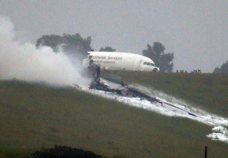ALHY 107.jpg :: Parts of debris burns as an A300 cargo plane lies on a hill at Birmingham Shuttlesworth International Airport after crashing on approach this morning Wednesday August 14,  2013 in Birmingham, Ala. (Photo/Hal Yeager)
