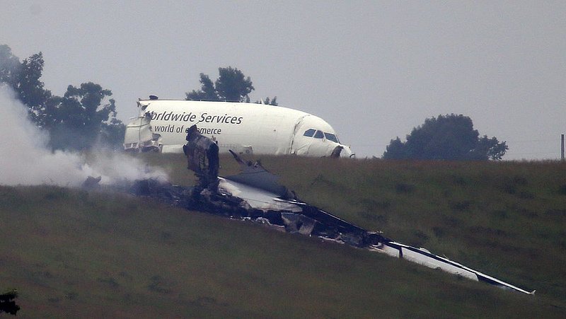 ALHY 108.jpg :: Parts of debris burns as an A300 cargo plane lies on a hill at Birmingham-Shuttlesworth International Airport after crashing on approach this morning Wednesday August 14,  2013 in Birmingham, Ala. (Photo/Hal Yeager)