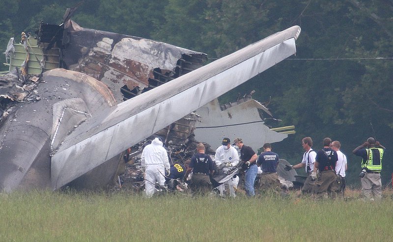 ALHY107.jpg :: NTSB investigators remove a large piece of debris from the tail section of the UPS cargo plane that crashed on approach to the Birmingham-Shuttlesworth International Airport August 15,  2013 in Birmingham, Ala. (Photo/Hal Yeager)