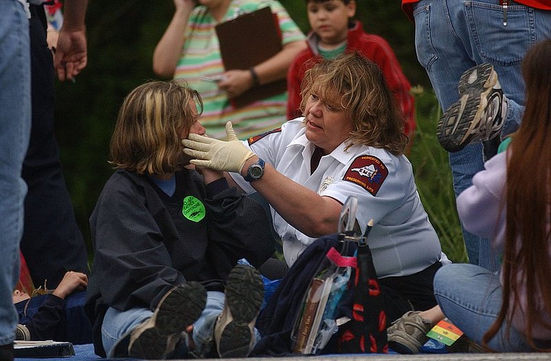 BUS WRECK_003.jpg :: BUS WRECK--Two chartered busses collided on I-59 at the 162 mile marker injuring some of the passengers that included many school children. A medical person checks on a victim. News staff/Hal Yeager reporter/Sims