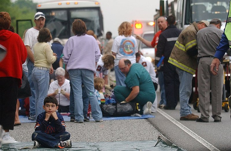 BUS WRECK_004.jpg :: BUS WRECK--Two chartered busses collided on I-59 at the 162 mile marker injuring some of the passengers that included many school children. A child waits to be checked by medical personnel. News staff/Hal Yeager reporter/Sims