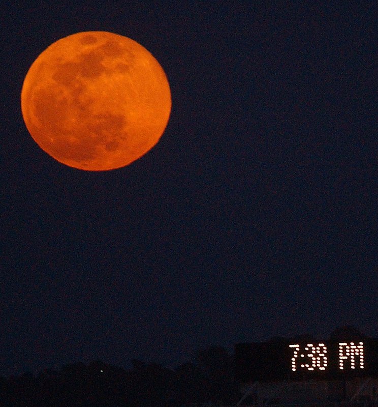 FULL MOON 2 .jpg :: The full moon rises over downtown Birmingham as a message board on ttop of a building flashes the time.  April's full moon has been called the Grass Moon, Egg Moon and Full Fish Moon. This year, this full moon is also near perigee, its closest point to Earth in the moon's monthly orbit.  