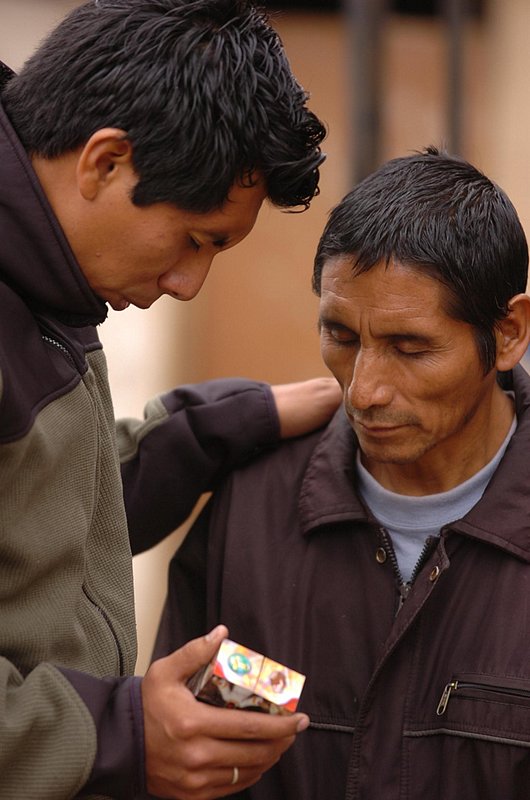 PERU_019.jpg :: PERU-----Eight members of ClearBranch UMC, Ron and Patty Bunch, Audrey Warren and her mother Edie Smith, Bob Coburn, Paul Henderson and Hal and Teann Yeager  traveled to Lima, Peru on an week-long medical/construction mission trip. Evangelist Felix Santiago prays with a man who came to the free clinic.  News staff/Hal Yeager  reporter/Garrison