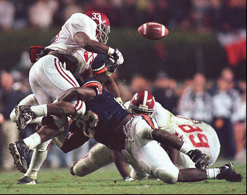 SCISSUM YEAR.jpg :: FILE -- Auburn strong safety Martavious Houston hits Alabama's Ed Scissum, causing him to fumble, setting up the winning Auburn field goal, at Auburn, in this November 22, 1997 photo. Alabama battles Alabama on December 8th. (AP Photo/The Birmingham News,Hal Yeager,File)