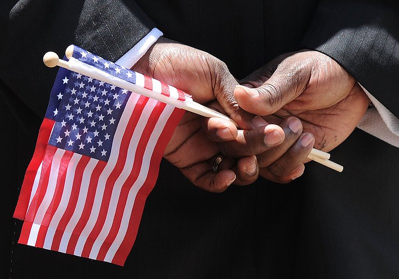 VETERANS PARADE 32.jpg :: A man holds flags he is handing out as he participates in a Welcome Home Veterans parade in front of City Hall Wednesday June 6, 2012 in Birmingham, Ala.  (The Birmingham News,Hal Yeager)