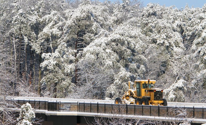WINTER WEATHER ALHY101A1.jpg :: A road grader scrapes snow off a highway 35 bridge atop Lookout Mountain Thursday, Feb. 13,  2014 in Fort Payne Ala. Resident of north Alabama woke to a covering of several inches of snow. (AP Photo/Hal Yeager)
