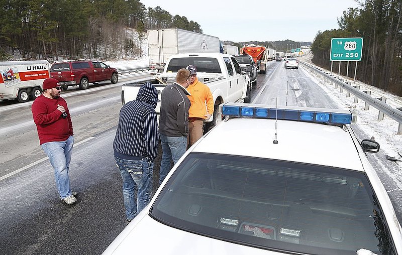 WINTER WEATHER ALHY102A.jpg :: Drivers talk with a Jefferson county sheriffs deputy as Traffic is at a standstill on Interstate 65 northbound as officials work to clear abandoned vehicles Wednesday January 29,  2014 in Pelham,  Ala.  (AP Photo/Hal Yeager)