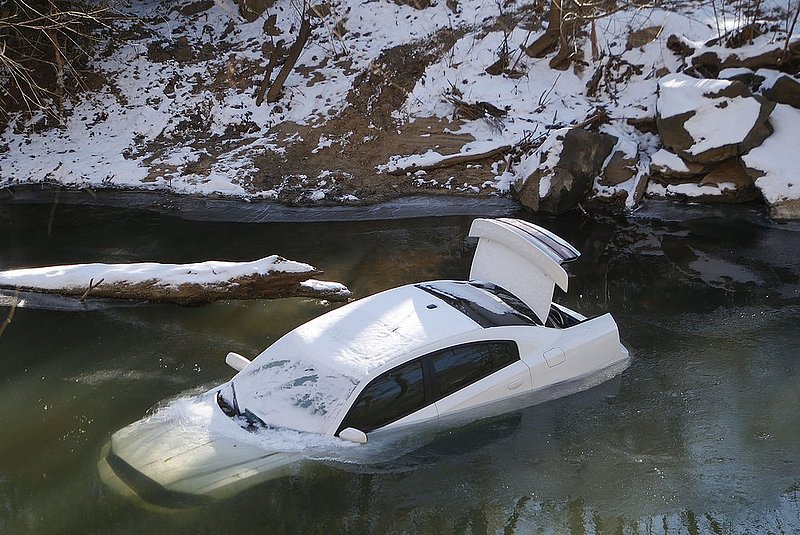 WINTER WEATHER ALHY104                     .jpg :: A car lies half submerged in the Cahaba River Thursday January 30,  2014 in Mountain Brook,  Ala. The driver was able to escape before the car slid into the river during Tuesday's snow storm and was not injured. (AP Photo/Hal Yeager)