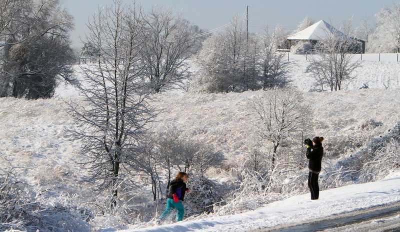 WINTER WEATHER ALHY104A1.jpg :: Loriah Goggans takes a photo of her daughter Madeline, 8, in a snow and ice covered landscape Thursday, Feb. 13,  2014 in Fort Payne Ala. A snow storm covered much of central and north Alabama Wednesday night with several inches of snow.  (AP Photo/Hal Yeager)