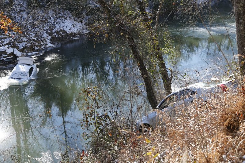 WINTER WEATHER ALHY105                       .jpg :: One car lies half submerged in the Cahaba River and another was stopped by a tree on the bank Thursday January 30,  2014 in Mountain Brook,  Ala. The one driver was able to escape before the car slid into the river during Tuesday's snow storm and was not injured.  Abandoned vehicles still litter the roadways two days after Tuesday's snow storm. (AP Photo/Hal Yeager)