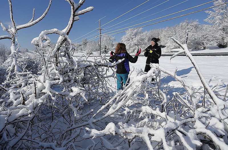 WINTER WEATHER ALHY107A.jpg :: Loriah Goggans takes a photo of her daughter Madeline, 8, in a snow and ice covered landscape Thursday, Feb. 13,  2014 in Fort Payne Ala. A snow storm covered much of central and north Alabama Wednesday night with several inches of snow. (AP Photo/Hal Yeager)