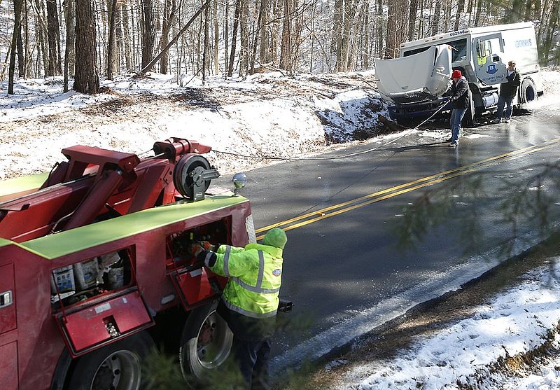 WINTER WEATHER ALHY109                              .jpg :: A wrecker works to free Brinks vehicle from a ditch on Ziegler road Thursday January 30,  2014 in Leeds,  Ala.  The south woke up to more freezing temperatures but officials are hoping for a thaw and relief from the icy conditions. (AP Photo/Hal Yeager)