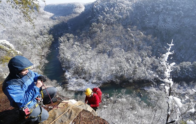 WINTER WEATHER ALHY110A1.jpg :: Hobie McQuade assists Israel Partridge of True Adventure Sports prepare as he prepares to rappel into a snow and ice covered Little River Canyon Thursday, Feb. 13,  2014 near Fort Payne Ala. A snow storm covered much of central and north Alabama Wednesday night with several inches of snow.  (AP Photo/Hal Yeager)