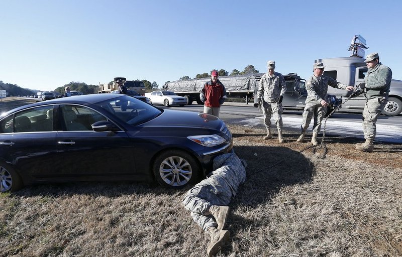 WINTER WEATHER ALHY111                                 .jpg :: Alabama Army National Guard troops assist Tommy Holmes with his stuck vehicle on interstate 20 Thursday Jan. 30,  2014 in Leeds,  Ala. The south woke up to more freezing temperatures but officials are hoping for a thaw and relief from the icy conditions. (AP Photo/Hal Yeager)