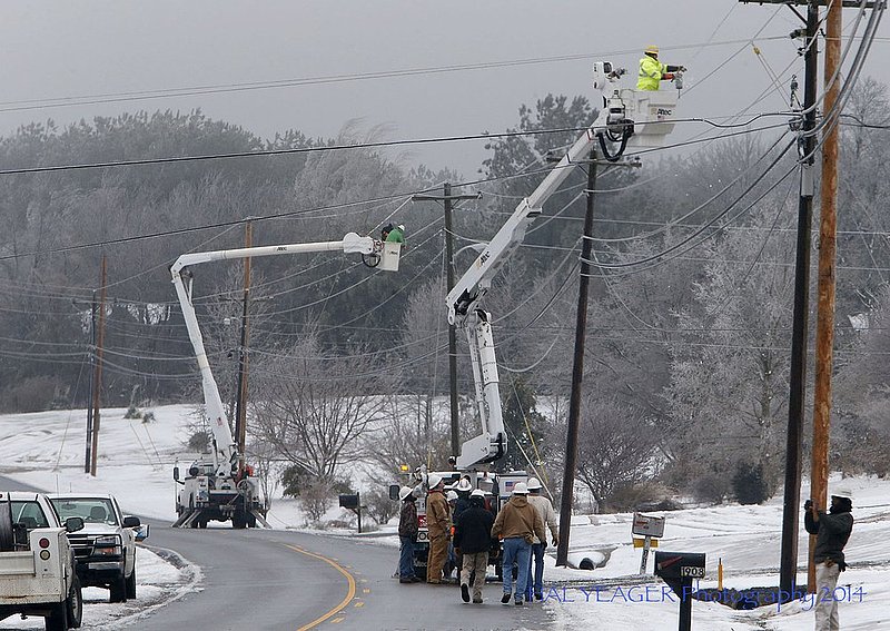WINTER WEATHER ALHY112 16-54-57-062.jpg :: Fort Payne Improvement Authority workers work on lines that had become heavy with ice and were being blown around by high winds Wednesday Feb. 12,  2014 in Dog Town,  Ala. Officials are warning of ice and snow accumulations as the day continues. (AP Photo/Hal Yeager)