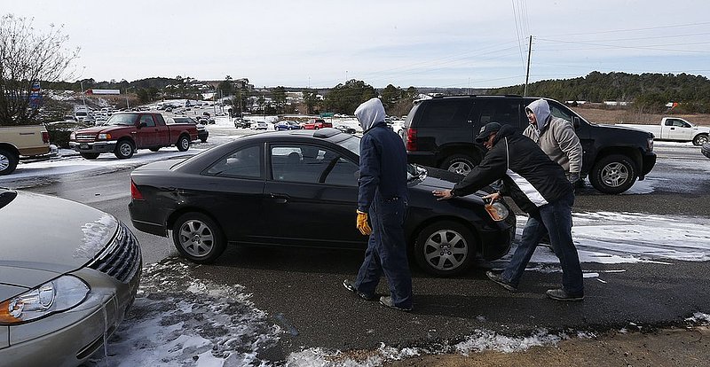 WINTER WEATHER ALHY113  .jpg :: A driver is assisted on US highway 78 as they try to push a car off a sheet of ice  Wednesday January 29,  2014 in Leeds,  Ala.  (AP Photo/Hal Yeager)