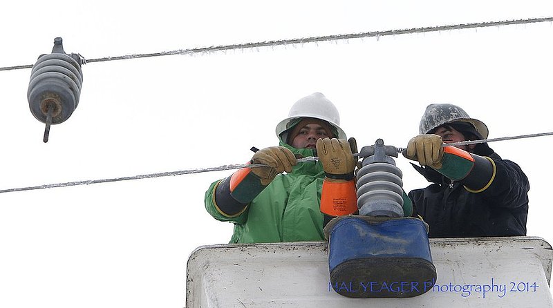 WINTER WEATHER ALHY113 16-54-57-092.jpg :: Fort Payne Improvement Authority workers Jonathan Henderson and Lance Woods work on lines that had become heavy with ice and were being blown around by high winds Wednesday Feb. 12,  2014 in Dog Town,  Ala. Officials are warning of ice and snow accumulations as the day continues. (AP Photo/Hal Yeager)