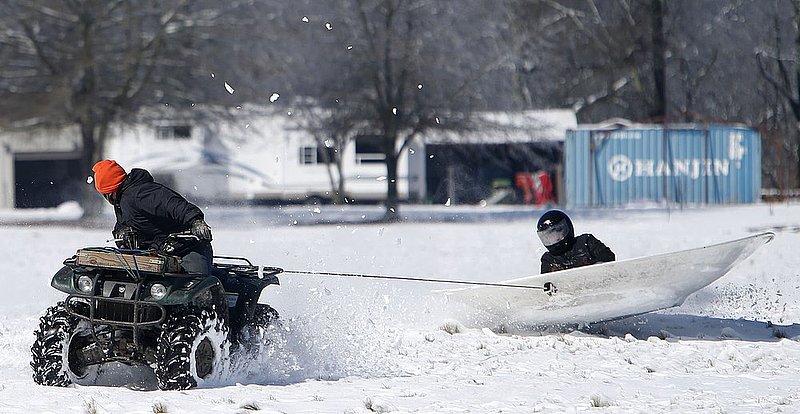 WINTER WEATHER ALHY113A.jpg :: Daniel Henderson Pulls Justin Tishaw in a satellite dish on a snow covered field Thursday, Feb. 13,  2014 in Fort Payne Ala.  (AP Photo/Hal Yeager)