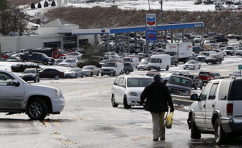 WINTER WEATHER ALHY114  .jpg :: A man carries a sack of food back to his stranded vehicle  Wednesday January 29,  2014 in Leeds,  Alabama at an exit off of Interstate 20 where hundreds of motorists were stranded the day before. (AP Photo/Hal Yeager)
